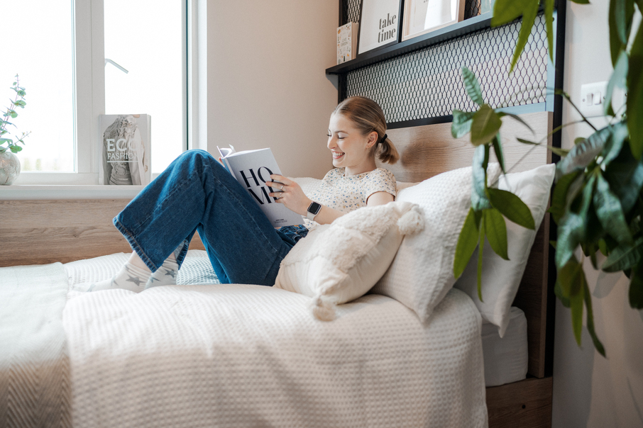 Student reading fashion book in bed