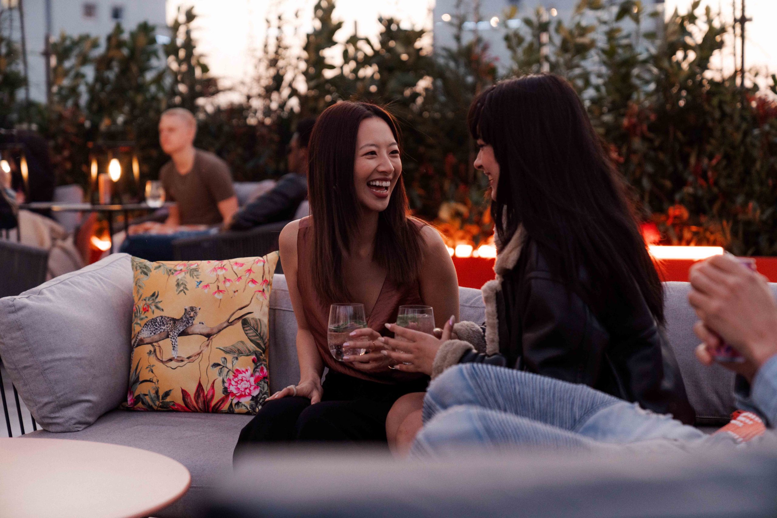 Two students laughing and socialising on rooftop terrace