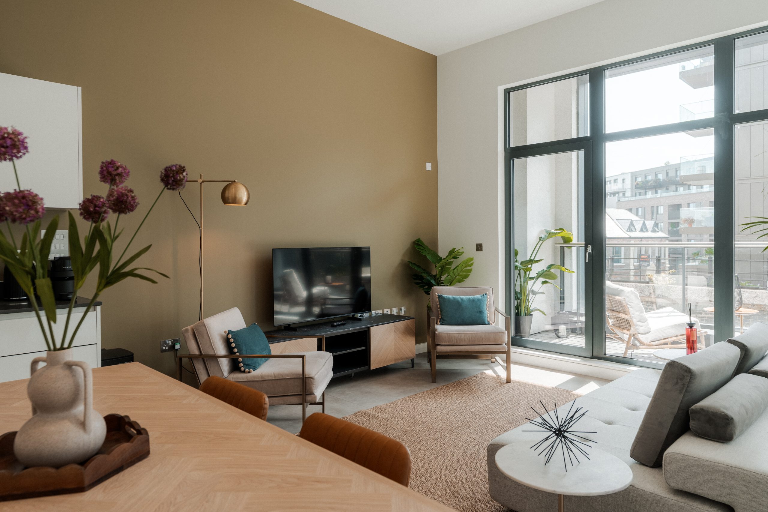 Student shared living area inside a YourTRIBE Depford duplex room with seating, TV and dining table.