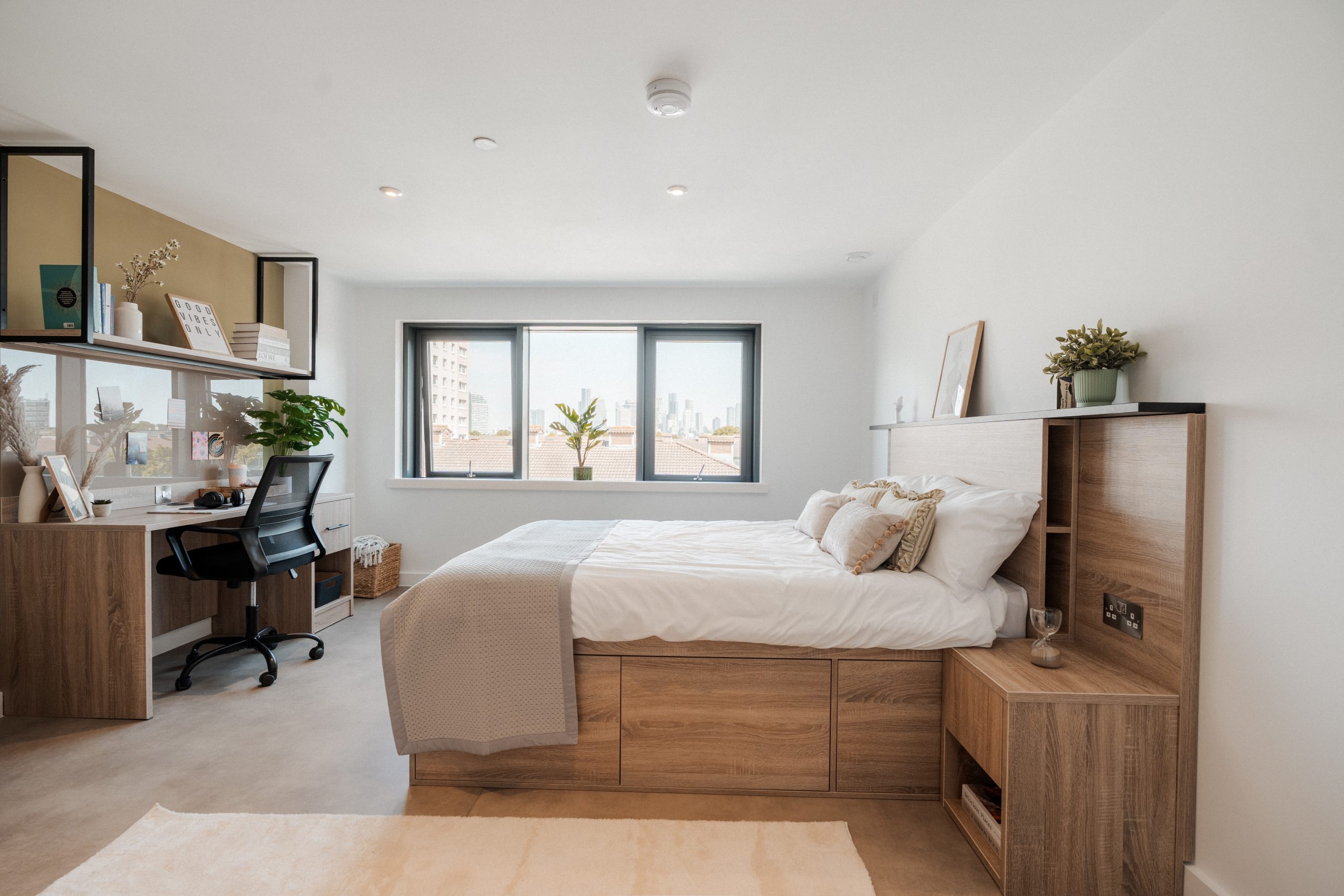 YourTRIBE student accommodation room with bed, desk and window overlooking the London skyline