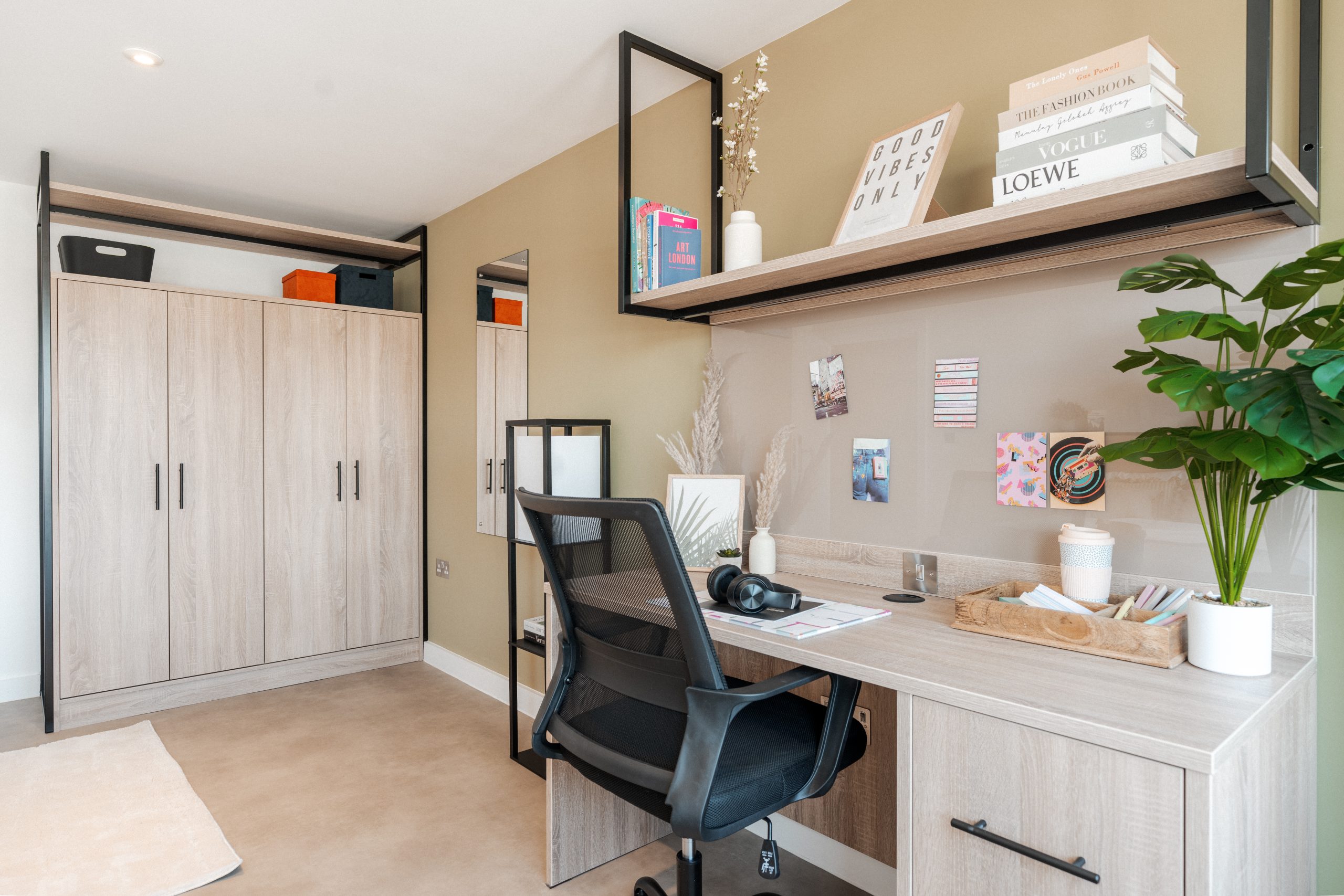 Wooden desk area and wooden wardrobes inside a student accommodation room.
