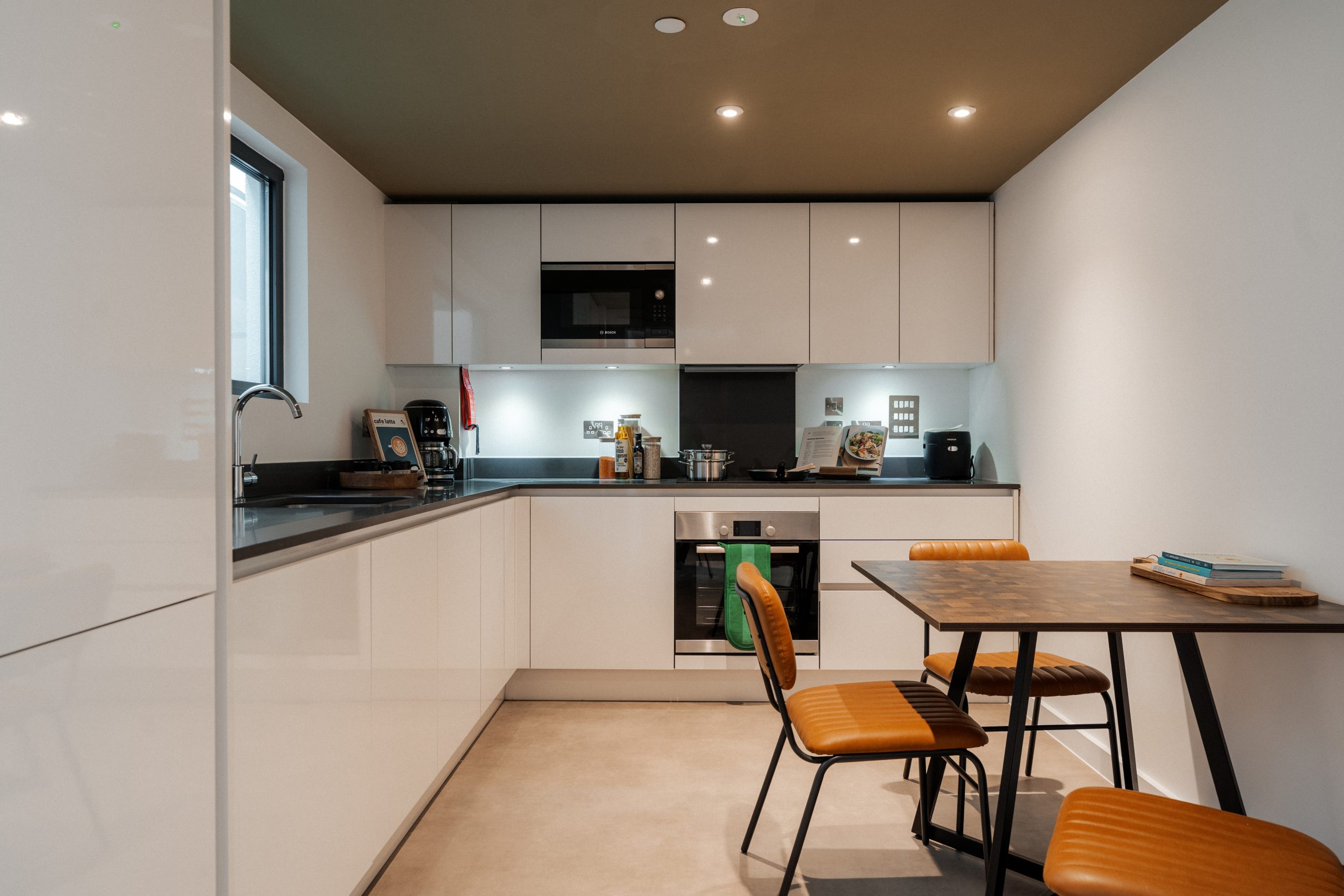 Kitchen area inside student accommodation with dining table, oven and microwave
