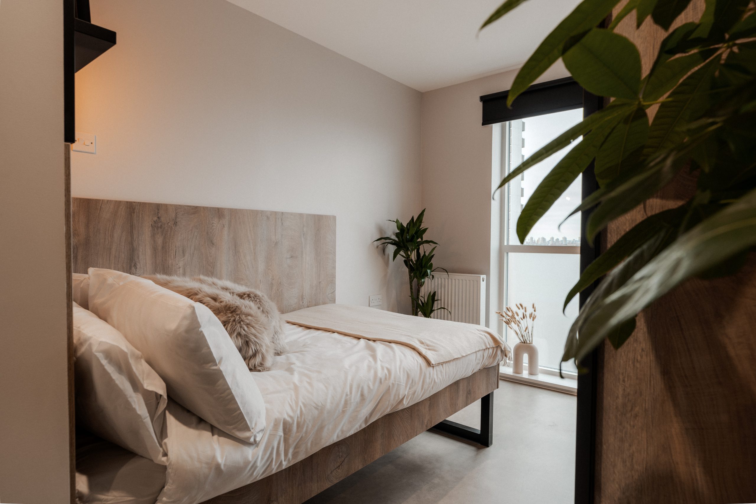Neutral student bedroom with the bed overlooking the window