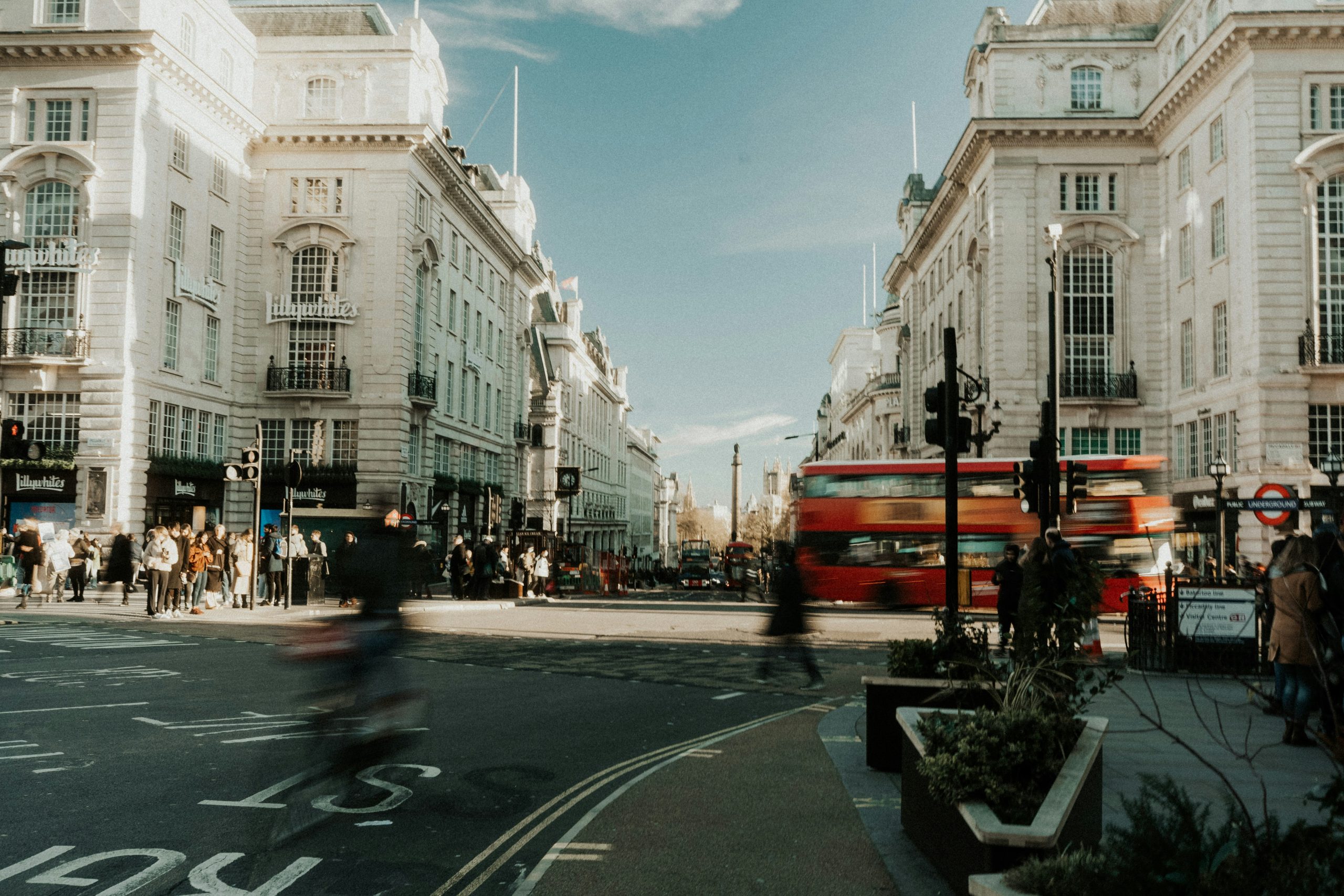 Red London bus passing Piccadilly Circus Underground station