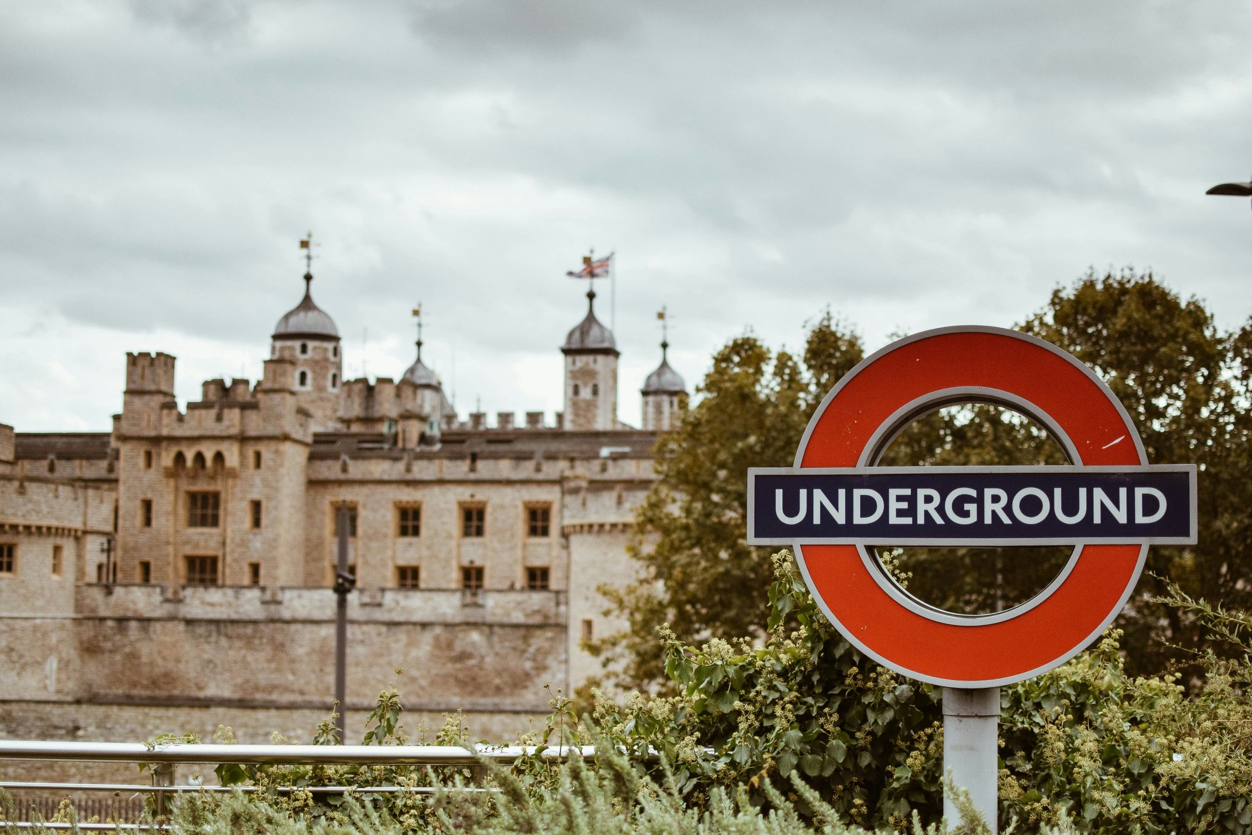 London Underground sign with the Tower of London behind it